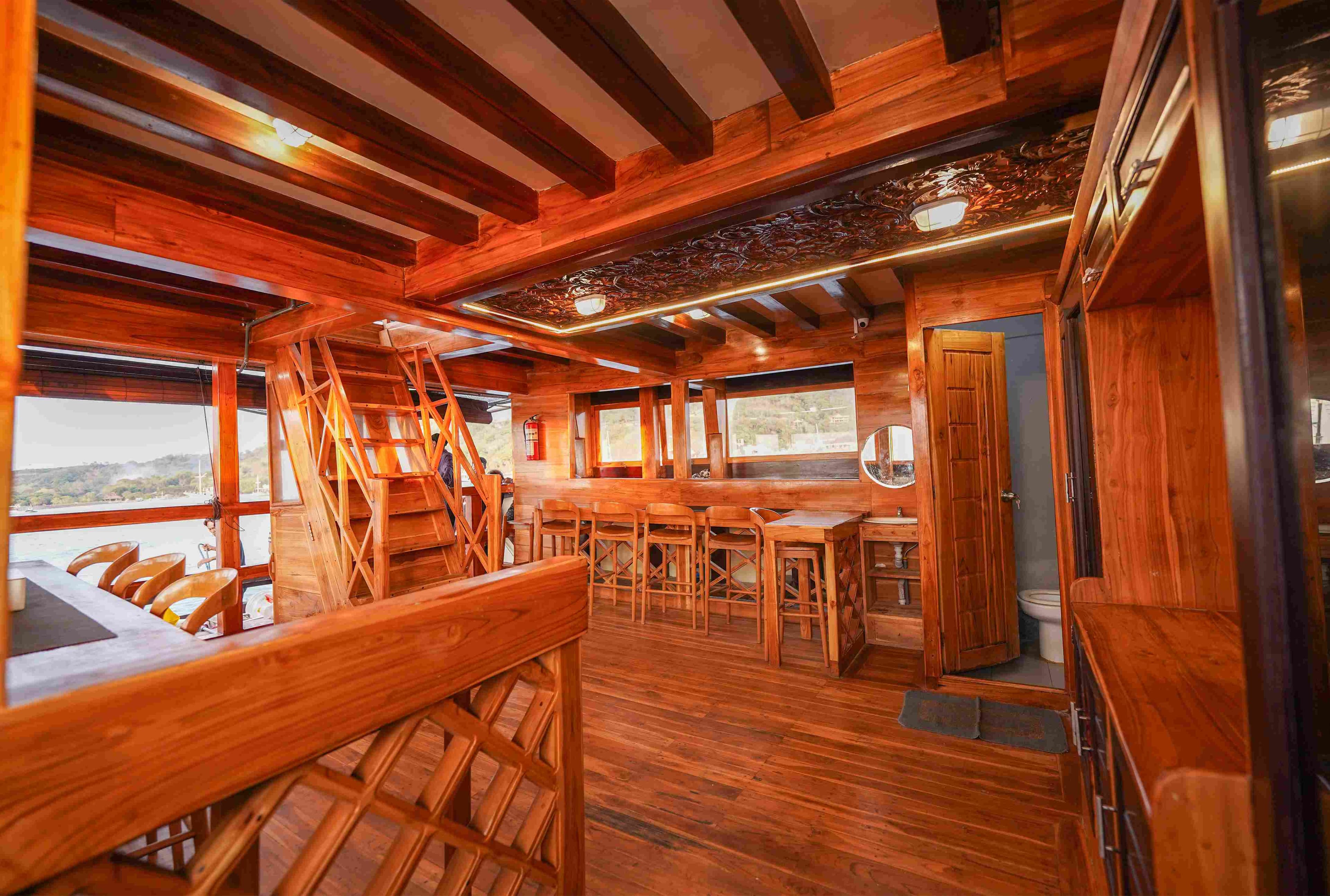 Cozy, wood-paneled indoor dining room with panoramic ocean windows