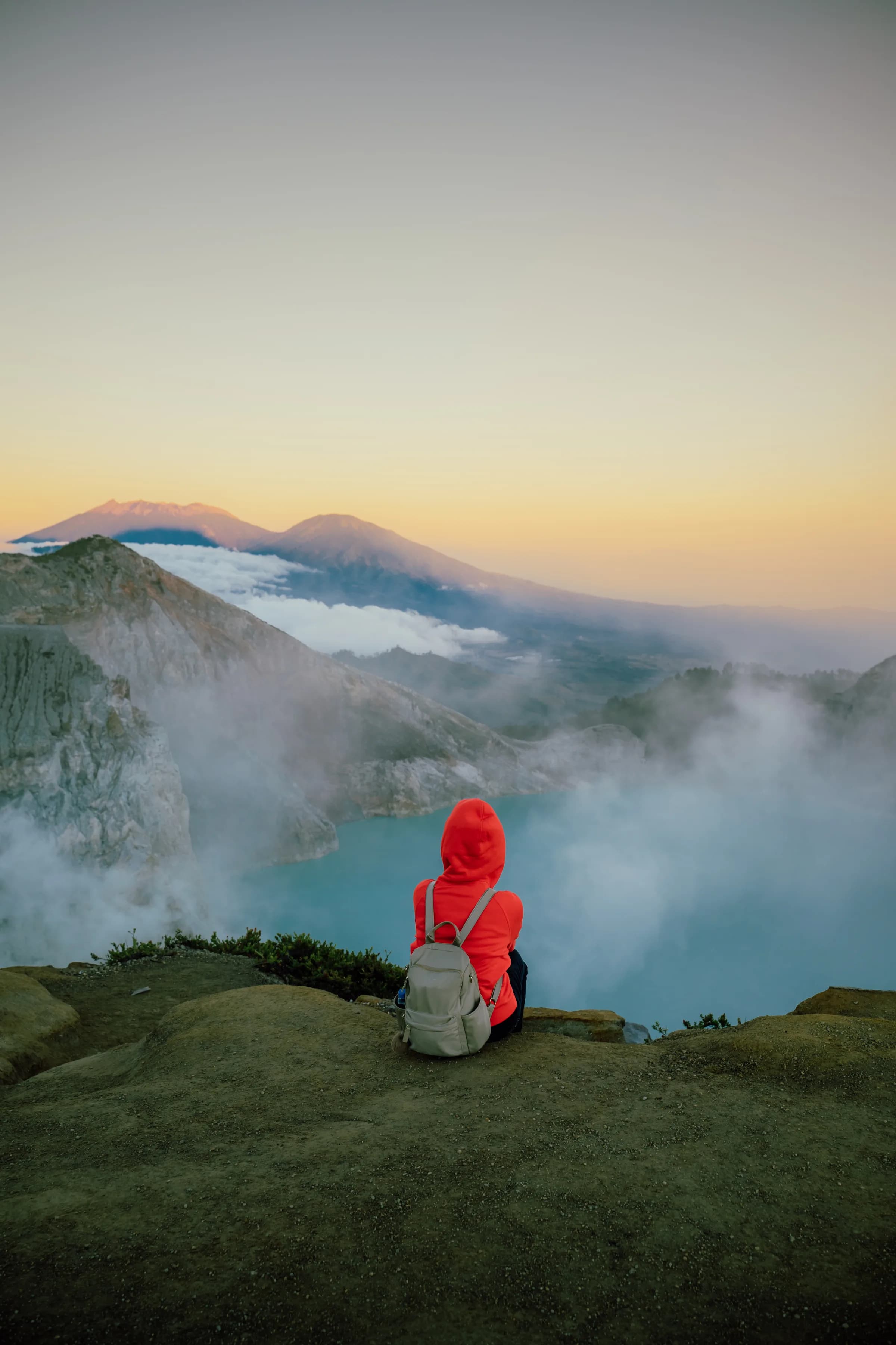 Trekker overlooking the Ijen crater lake at first light from the rim