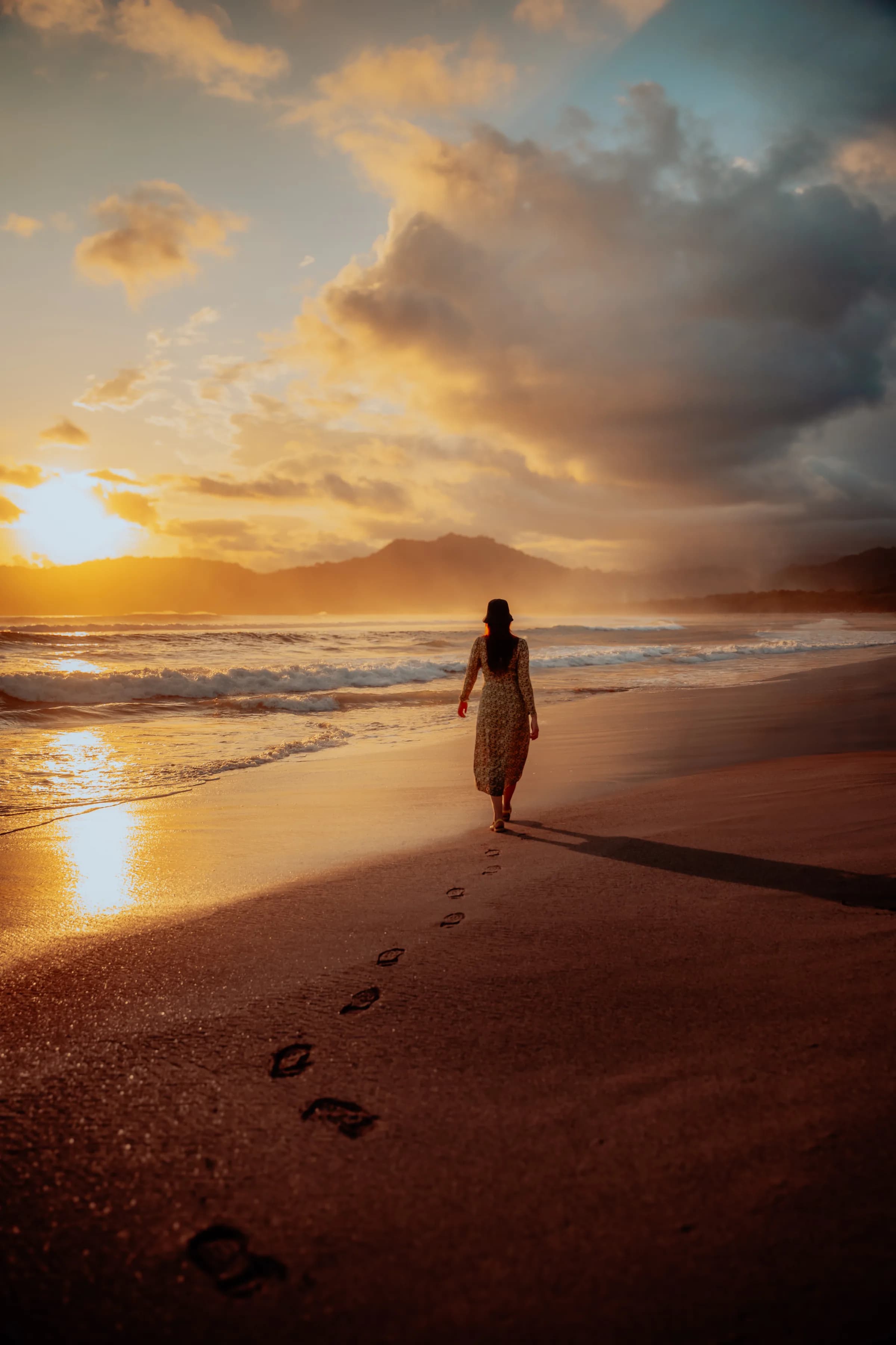 A lone figure walking the sunset shore at Pulau Merah